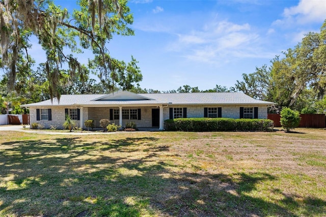 single story home with a front yard, fence, and stone siding