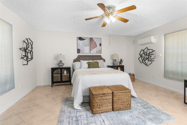 bedroom with baseboards, a textured ceiling, light tile patterned floors, and a wall mounted air conditioner