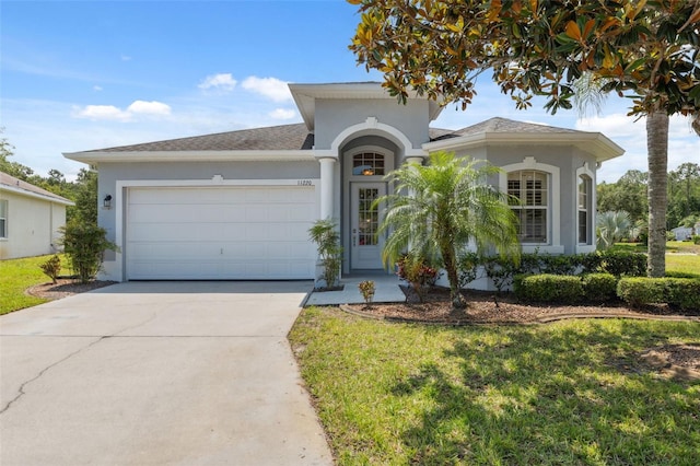 11220 Godwit Ct, New Port Richey, FL 34654 - view of front of property featuring an attached garage, stucco siding, driveway, and a front yard