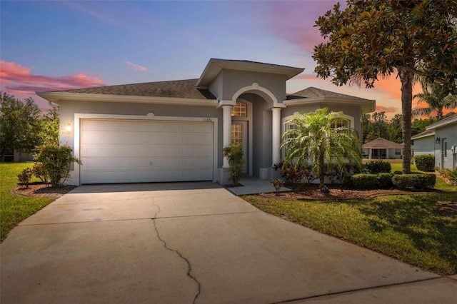 11220 Godwit Ct, New Port Richey, FL 34654 - mediterranean / spanish house featuring stucco siding, concrete driveway, a garage, and a yard