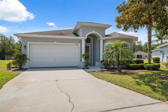 11220 Godwit Ct, New Port Richey, FL 34654 - view of front of home featuring stucco siding, an attached garage, concrete driveway, and a front yard