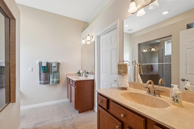 11220 Godwit Ct, New Port Richey, FL 34654 - bathroom with tiled shower, two vanities, tile patterned flooring, and baseboards