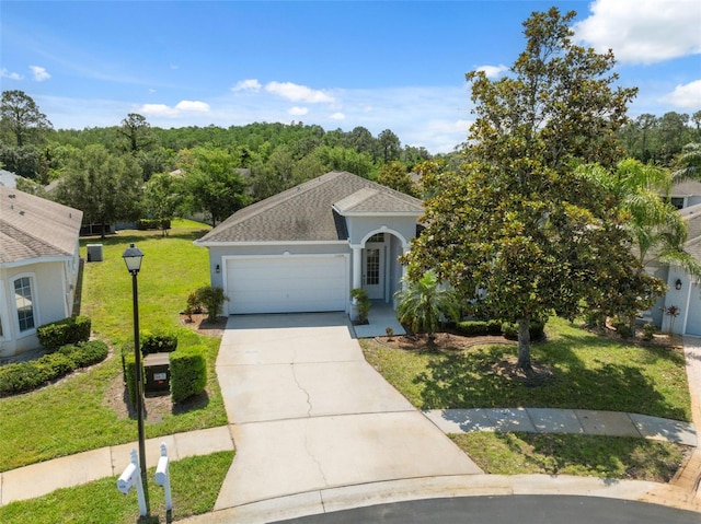 11220 Godwit Ct, New Port Richey, FL 34654 - view of front facade featuring an attached garage, driveway, a front lawn, stucco siding, and a shingled roof