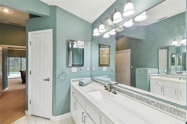 1831 Stable Trl, Palm Harbor, FL 34685 - bathroom featuring vaulted ceiling, two vanities, a sink, tile patterned floors, and baseboards