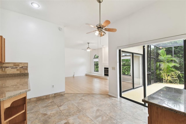 1831 Stable Trl, Palm Harbor, FL 34685 - unfurnished living room featuring a ceiling fan, baseboards, and a glass covered fireplace