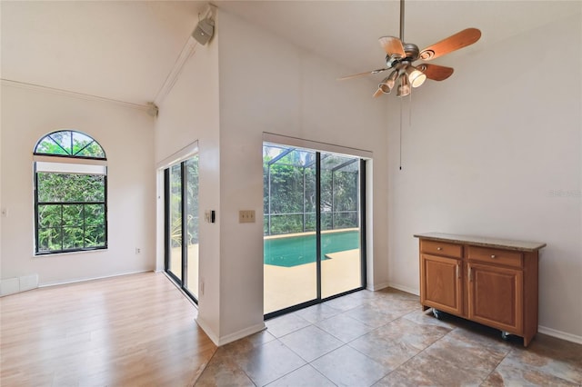 1831 Stable Trl, Palm Harbor, FL 34685 - spare room featuring a ceiling fan, high vaulted ceiling, and baseboards