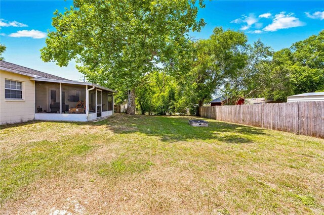 view of yard with a fenced backyard and a sunroom
