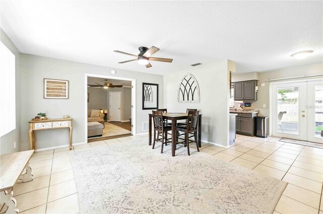 dining area with a ceiling fan, french doors, visible vents, and light tile patterned floors