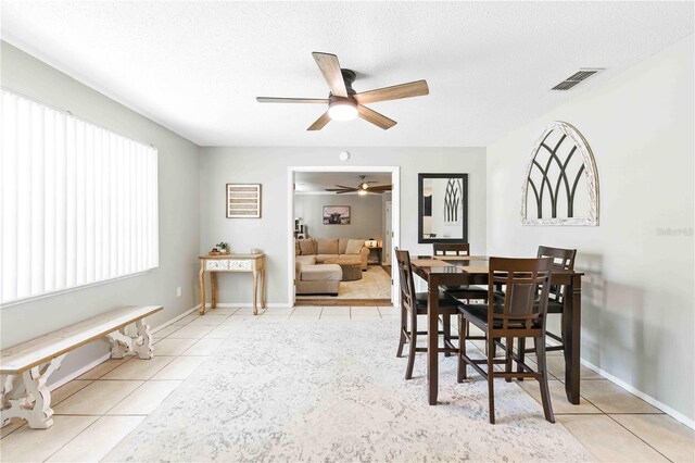 dining space featuring a textured ceiling, ceiling fan, visible vents, and tile patterned flooring