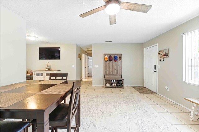 dining room with a ceiling fan, baseboards, visible vents, and light tile patterned floors