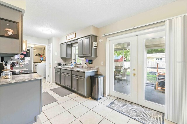 kitchen with a sink, light countertops, a textured ceiling, french doors, and gray cabinets