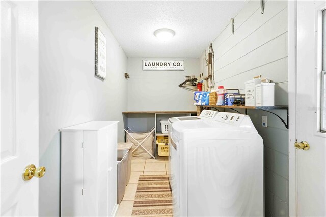 washroom featuring laundry area, a textured ceiling, light tile patterned flooring, and separate washer and dryer