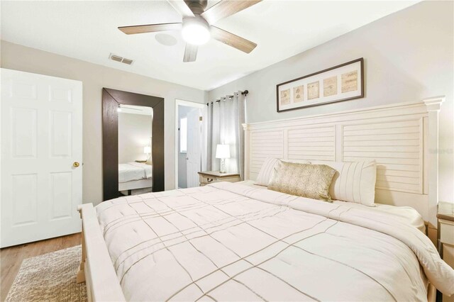 bedroom featuring a ceiling fan, light wood-style flooring, and visible vents