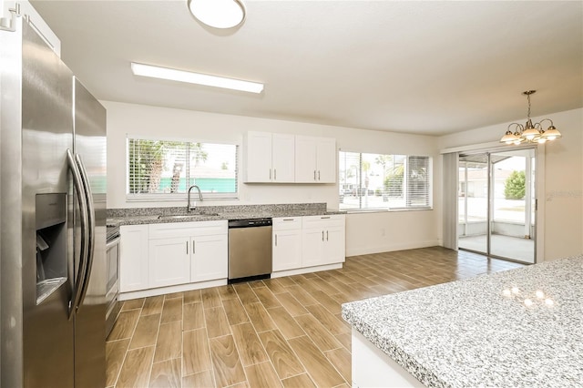kitchen with a notable chandelier, a wealth of natural light, stainless steel appliances, and a sink