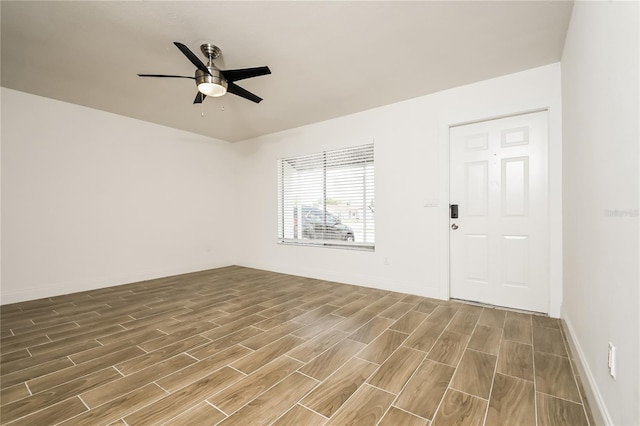 empty room with ceiling fan, baseboards, and wood finished floors