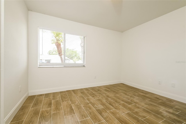 empty room with baseboards and wood finished floors