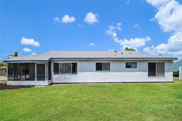 back of house featuring a sunroom, a yard, and stucco siding