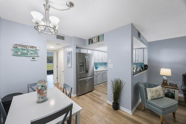 404 Hammock Pine Blvd Unit 404, Clearwater, FL 33761 - dining room with a textured ceiling, a notable chandelier, light wood-style flooring, and visible vents