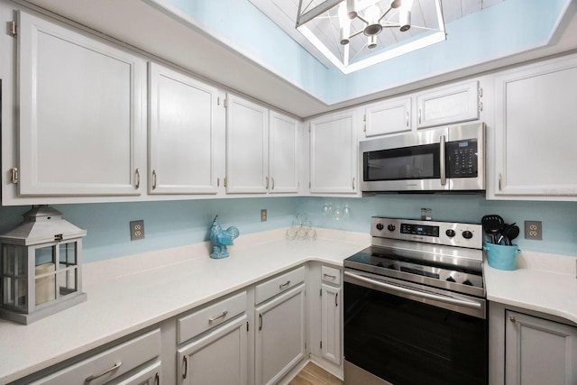 404 Hammock Pine Blvd Unit 404, Clearwater, FL 33761 - kitchen featuring light countertops, stainless steel appliances, white cabinetry, and a notable chandelier