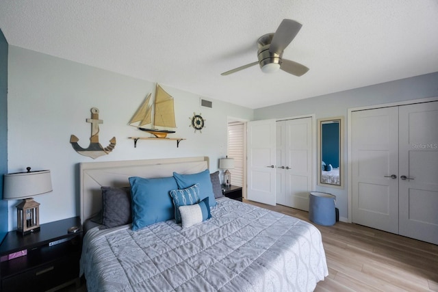 404 Hammock Pine Blvd Unit 404, Clearwater, FL 33761 - bedroom with a textured ceiling, multiple closets, visible vents, and light wood-style floors