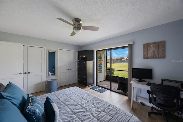 404 Hammock Pine Blvd Unit 404, Clearwater, FL 33761 - bedroom featuring two closets, wood finished floors, ceiling fan, access to outside, and a textured ceiling