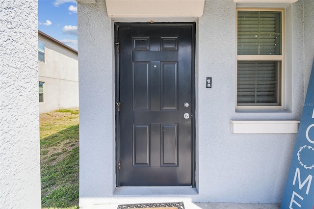 entrance to property with stucco siding
