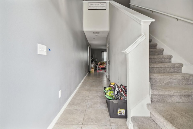 stairs featuring tile patterned floors and baseboards