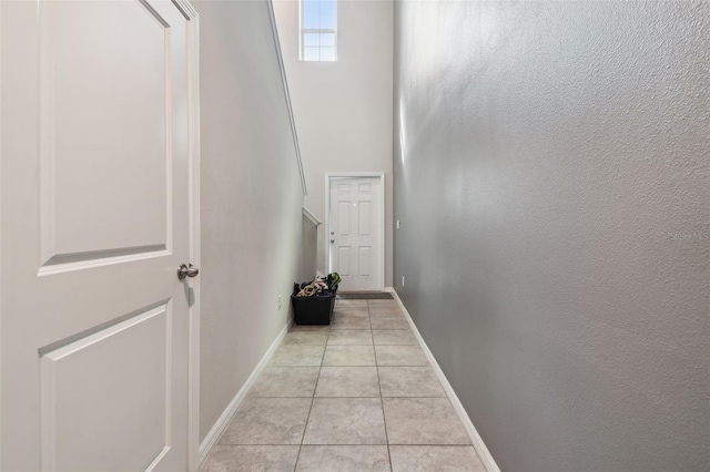 hallway with baseboards and light tile patterned floors