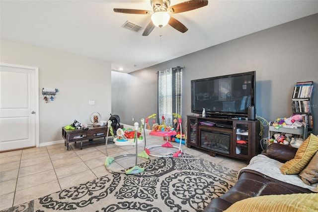 tiled living area featuring baseboards, a ceiling fan, and visible vents