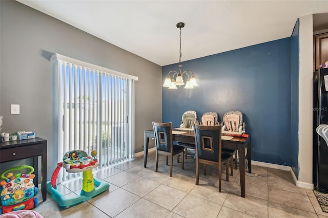 dining room featuring baseboards, light tile patterned flooring, and a chandelier