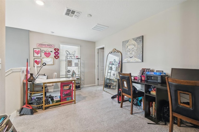 carpeted office space featuring baseboards and visible vents