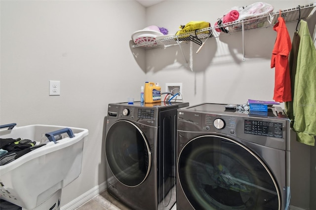 laundry area featuring washing machine and clothes dryer, laundry area, a sink, and baseboards