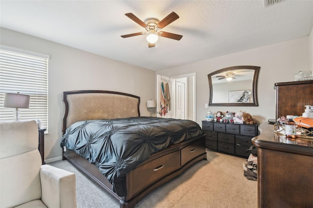 bedroom with visible vents, a ceiling fan, and light colored carpet