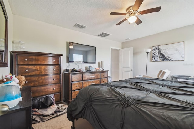 bedroom with carpet, a ceiling fan, a textured ceiling, and visible vents