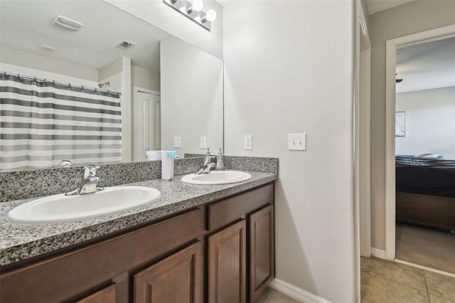 ensuite bathroom featuring a sink, ensuite bathroom, double vanity, and visible vents