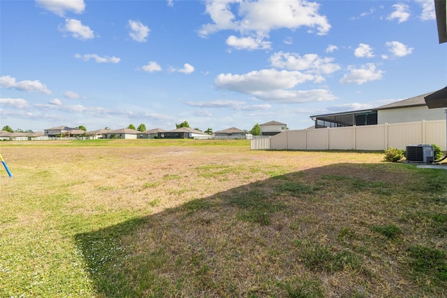 view of yard with central air condition unit and fence