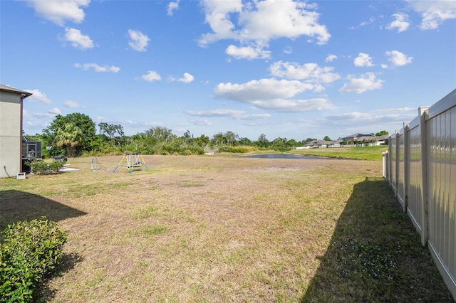 view of yard featuring a water view and fence