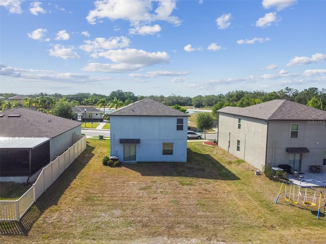 rear view of property with a yard and a shingled roof