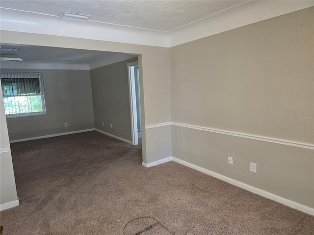 carpeted spare room featuring baseboards