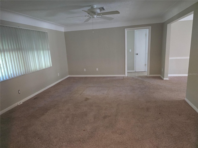 carpeted spare room featuring a ceiling fan and baseboards