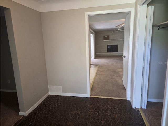 hallway featuring carpet floors, baseboards, and visible vents