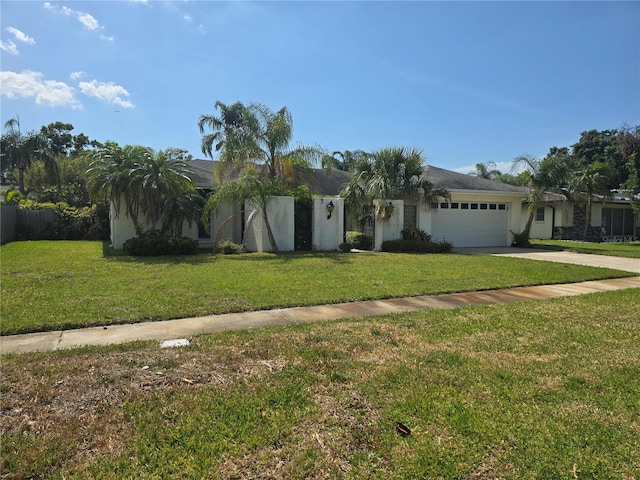 ranch-style home featuring a garage, stucco siding, driveway, and a front yard
