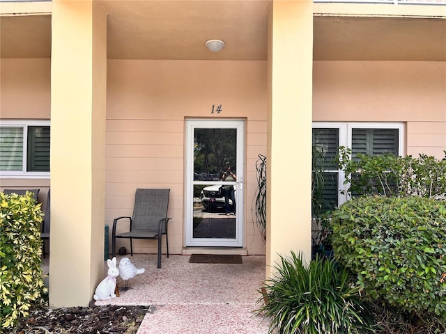 entrance to property featuring stucco siding