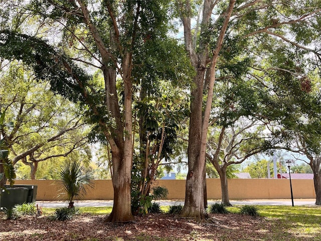 view of side of home featuring stucco siding and fence