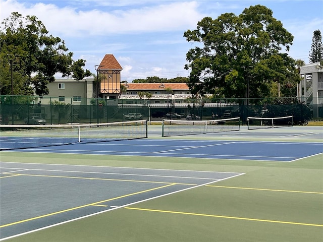 view of tennis court featuring fence and community basketball court