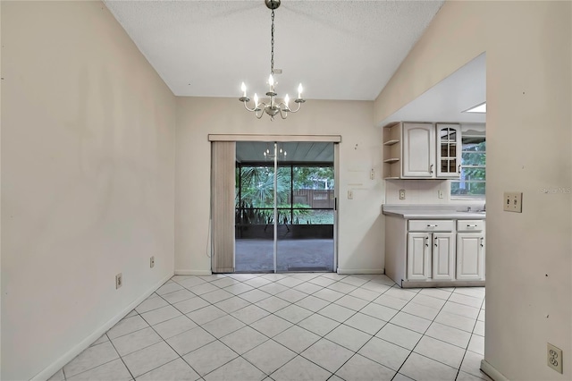 14615 Daybreak Dr, Lutz, FL 33559 - unfurnished dining area featuring a chandelier, plenty of natural light, light tile patterned flooring, and a textured ceiling