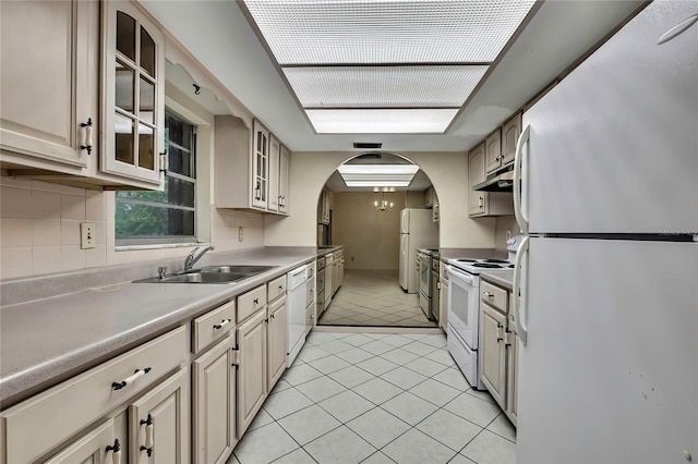 14615 Daybreak Dr, Lutz, FL 33559 - kitchen with white appliances, under cabinet range hood, light tile patterned flooring, glass insert cabinets, and arched walkways