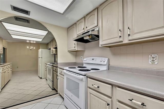 14615 Daybreak Dr, Lutz, FL 33559 - kitchen with white appliances, under cabinet range hood, a chandelier, light tile patterned floors, and light countertops