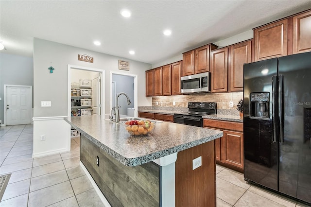 10148 Rose Petal Pl, Riverview, FL 33578 - kitchen with tasteful backsplash, a center island with sink, a sink, black appliances, and light tile patterned flooring