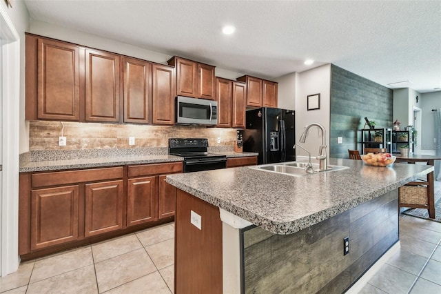 10148 Rose Petal Pl, Riverview, FL 33578 - kitchen featuring brown cabinets, a sink, light tile patterned floors, tasteful backsplash, and black appliances